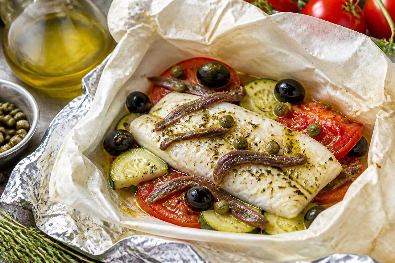 Recette de merlu, courgettes, tomates et anchois en papillote